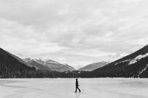 a woman walking across a frozen lake in Canada in winter 