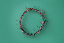 Crown of thorns on green background. Top view. Copy space. Christian Easter concept. Crucifixion of Jesus Christ. He risen and alive. Jesus is the reason. 