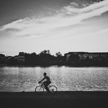 Man riding bicycle by lake
