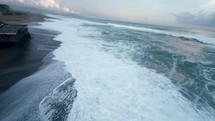 Stormy ocean crashing on sandy beach 