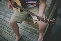 Man playing guitar on the dock
