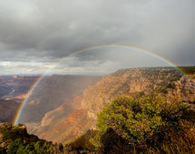 Rainbow over mountain canyon cliff