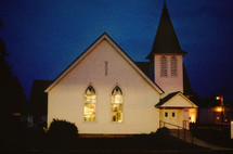A white church against a night  sky.