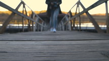 a woman with a camera walking on a wood dock 