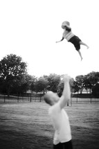 Father throwing baby up in air