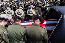 police officers putting a coffin into a hearse respect, honor highway patrol american flag casket salute 