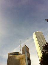 commercial airplane in the sky above sky scrapers