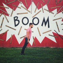 Man falling forward in front of a sign with the words BOOM