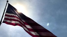 American Flag against blue sky with bokeh