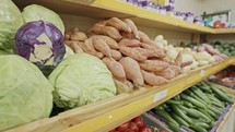 Large variety of vegetables and fruits on supermarket shelves.