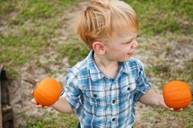 Boy holding two pumpkins