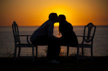Silhouettes of a man and woman kissing at sunset