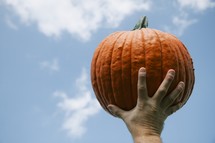 Man holding up pumpkin