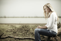 A woman practicing solitude & silence near a lake
