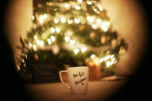 Christmas mug sitting in front of a tree