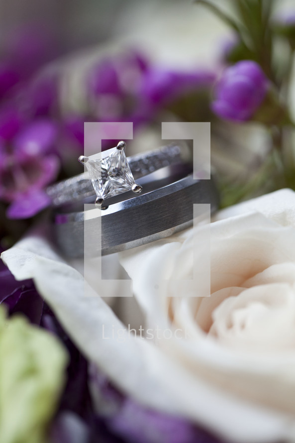 engagement ring and wedding band on bridal bouquet