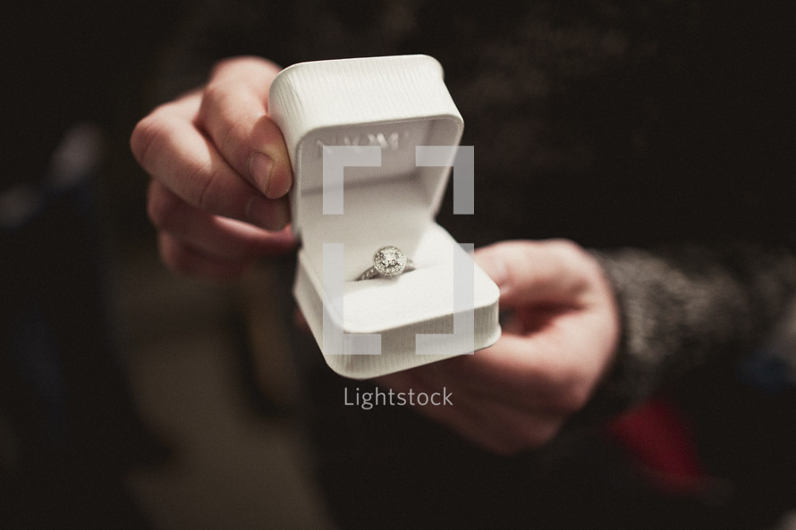 Man holding engagement ring in a box