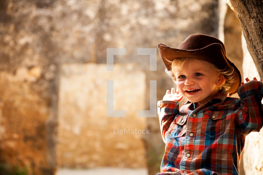 smiling toddler boy in a cowboy hat