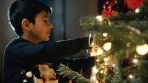 Kid Lighting a Christmas tree for holidays