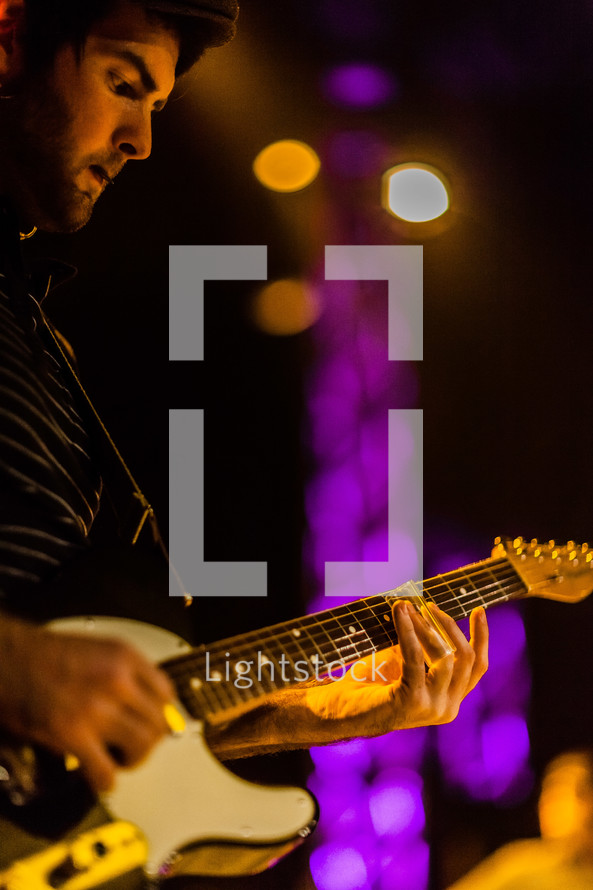 A man playing a electric guitar during worship