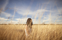 Girl sitting in wheat field
