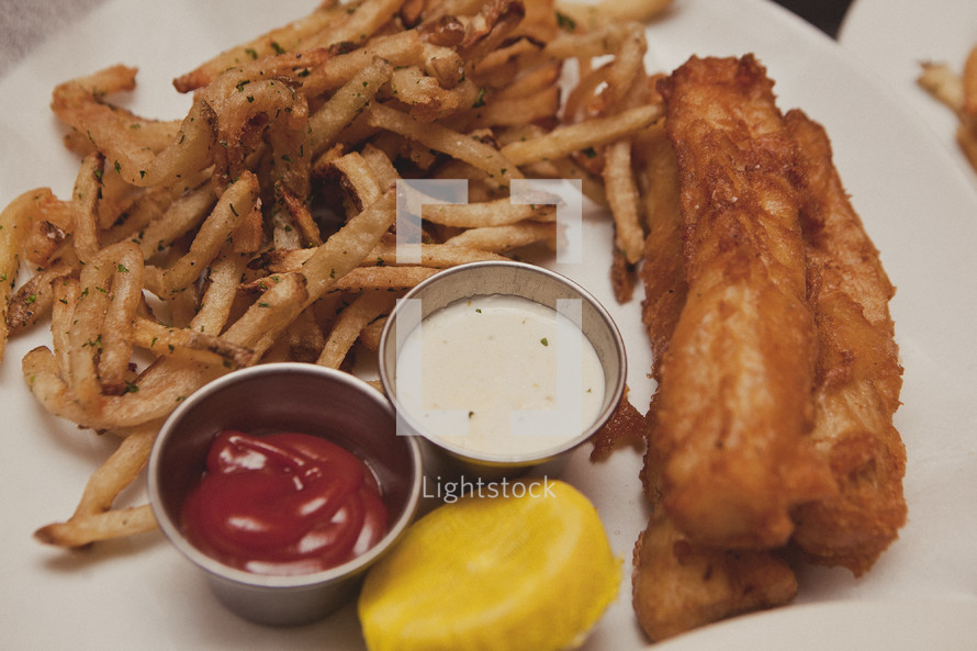 A plate of fried food - Chicken tenders and french fries