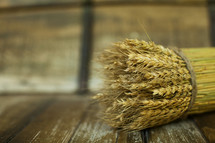 Bushel of wheat sitting on a wood table
