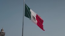 Slow Motion of The National Flag of Mexico on Blue Sky - Vertical Tricolor of Green, White, and Red with the National Coat of Arms Charged in the Center of the White Stripe