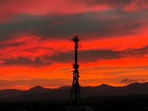 Silhouette of telecommunications tower at sunset