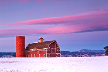 Red barn in the snow with the Colorado front range in the background