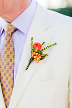mens orange floral on a lapel white suit yellow tie