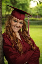 female graduate in red cap and gown 