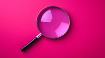 Magnifying glass on a magenta background. 