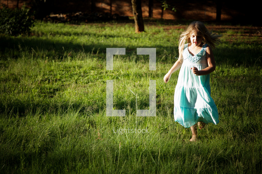 Little girl running in grass field