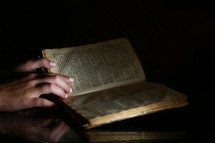 hands on an open Bible