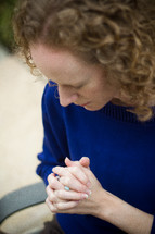 woman with her fingers laced in prayer