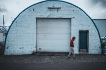 a man walking in front of a storage building 
