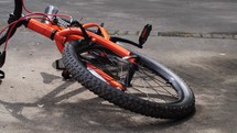 An orange bicycle and helmet in the driveway - tracking right and left motion