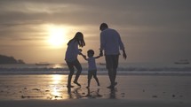 Portrait of Asian Indonesian Happy Family Father Mother and Child Spending Time Together at The Beach during Sunset - Relationship, Bond, Parenting, Laugh and Love