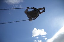 A kid swinging high into the sky