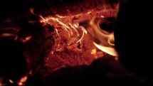 Red hot fire and coals burning wood and logs in camp fire in cinematic slow motion.