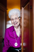 woman smiling from behind a door