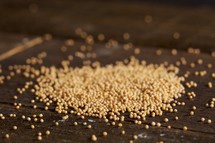 Scattered mustard seeds on wood table
