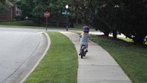 Young girl rides her bike in the neighborhood