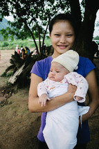 a young girl holding an infant 