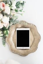 iPad on a silver tray and bouquet of pink flowers 