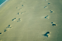 footprints in the sand on a beach 