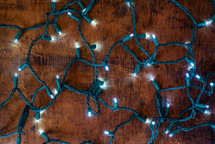 glowing string of Christmas lights on a wooden background 