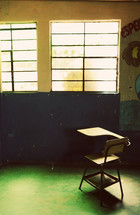 An solitary empty desk in a classroom