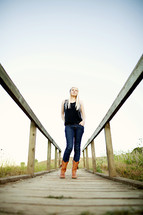 Young woman standing on a wood board walk boots fashion